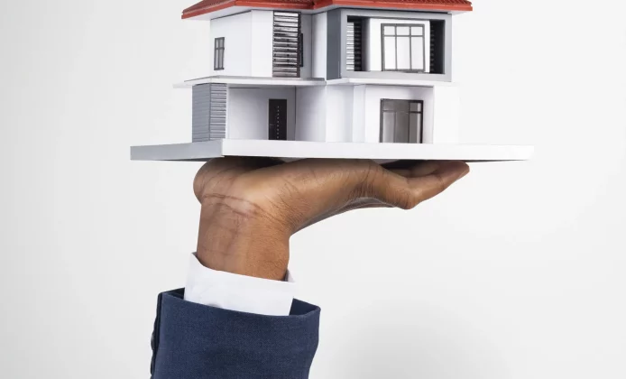 Hand holding house real estate and property model